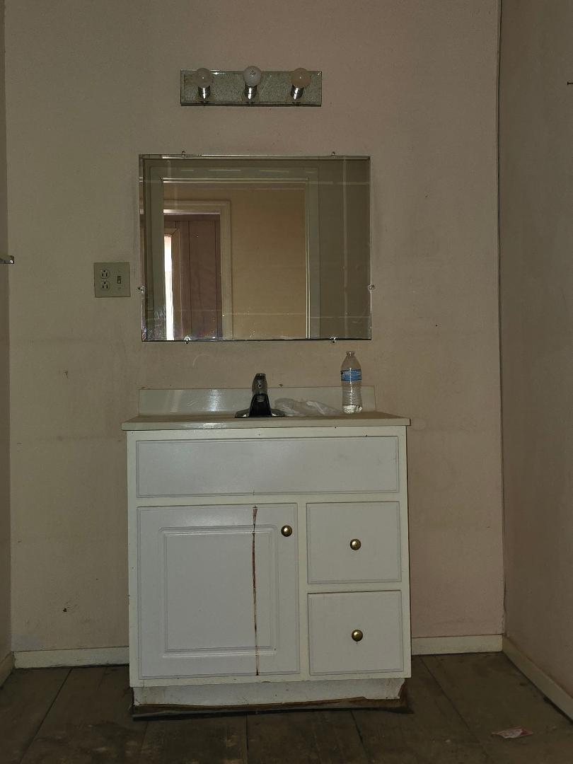 1506 North 1st Street Lamesa, TX 79331 - Photo 5 of 10 a bathroom with a sink vanity and mirror