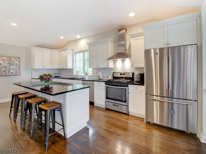 33 Cliffside Trail Denville, NJ 07834 - Photo 7 of 25 a kitchen with kitchen island white cabinets a refrigerator a stove a microwave and wooden floors