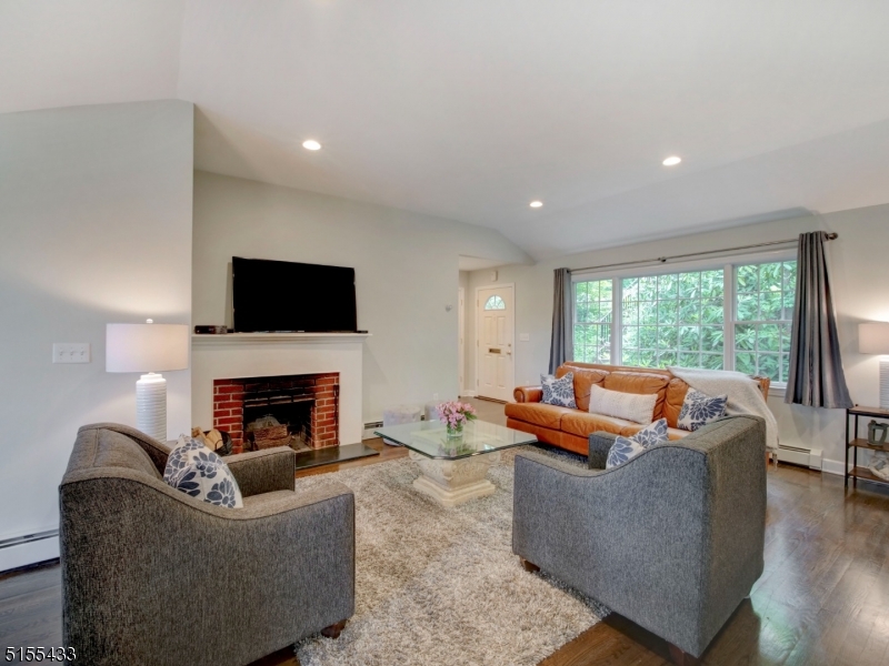 33 Cliffside Trail Denville, NJ 07834 - Photo 8 of 25 a living room with furniture flat screen tv and a fireplace