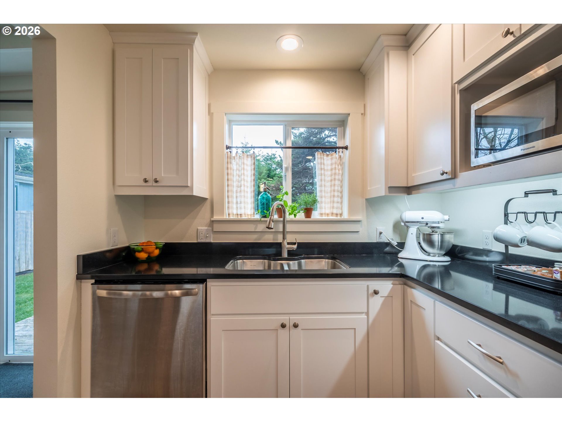 770 9th Street Southeast Bandon, OR 97411 - Photo 16 of 47 a kitchen with granite countertop a sink window and cabinets
