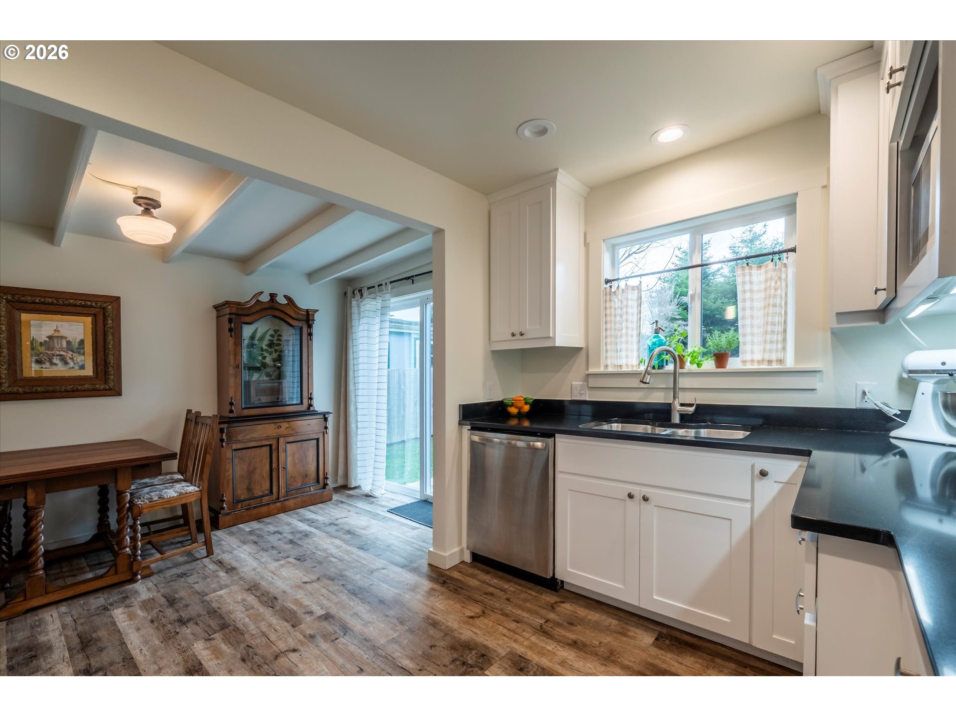 770 9th Street Southeast Bandon, OR 97411 - Photo 18 of 47 a kitchen with granite countertop a sink cabinets wooden floor and stainless steel appliances