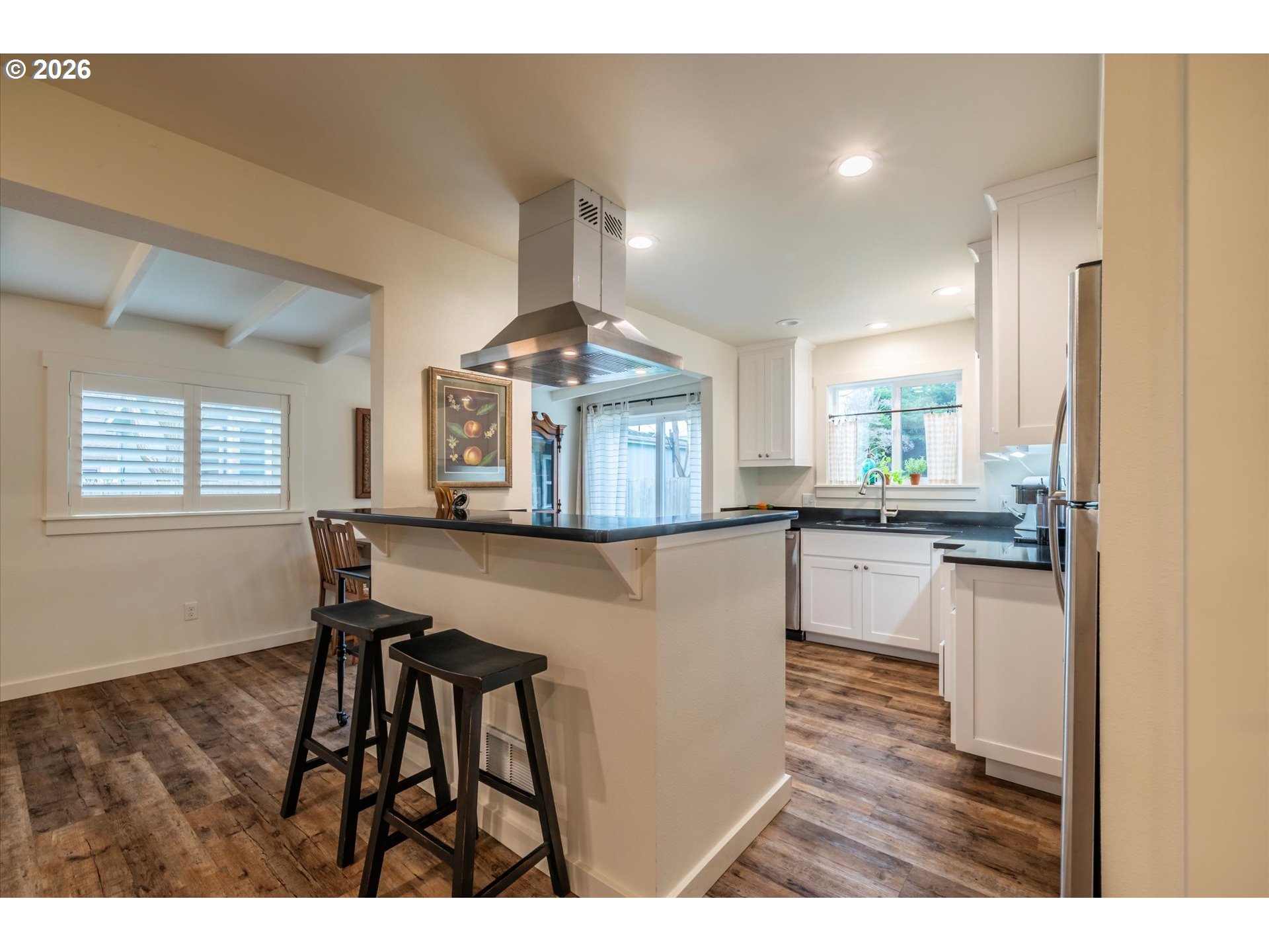 770 9th Street Southeast Bandon, OR 97411 - Photo 24 of 47 a kitchen with kitchen island a stove a sink a refrigerator and a dining table