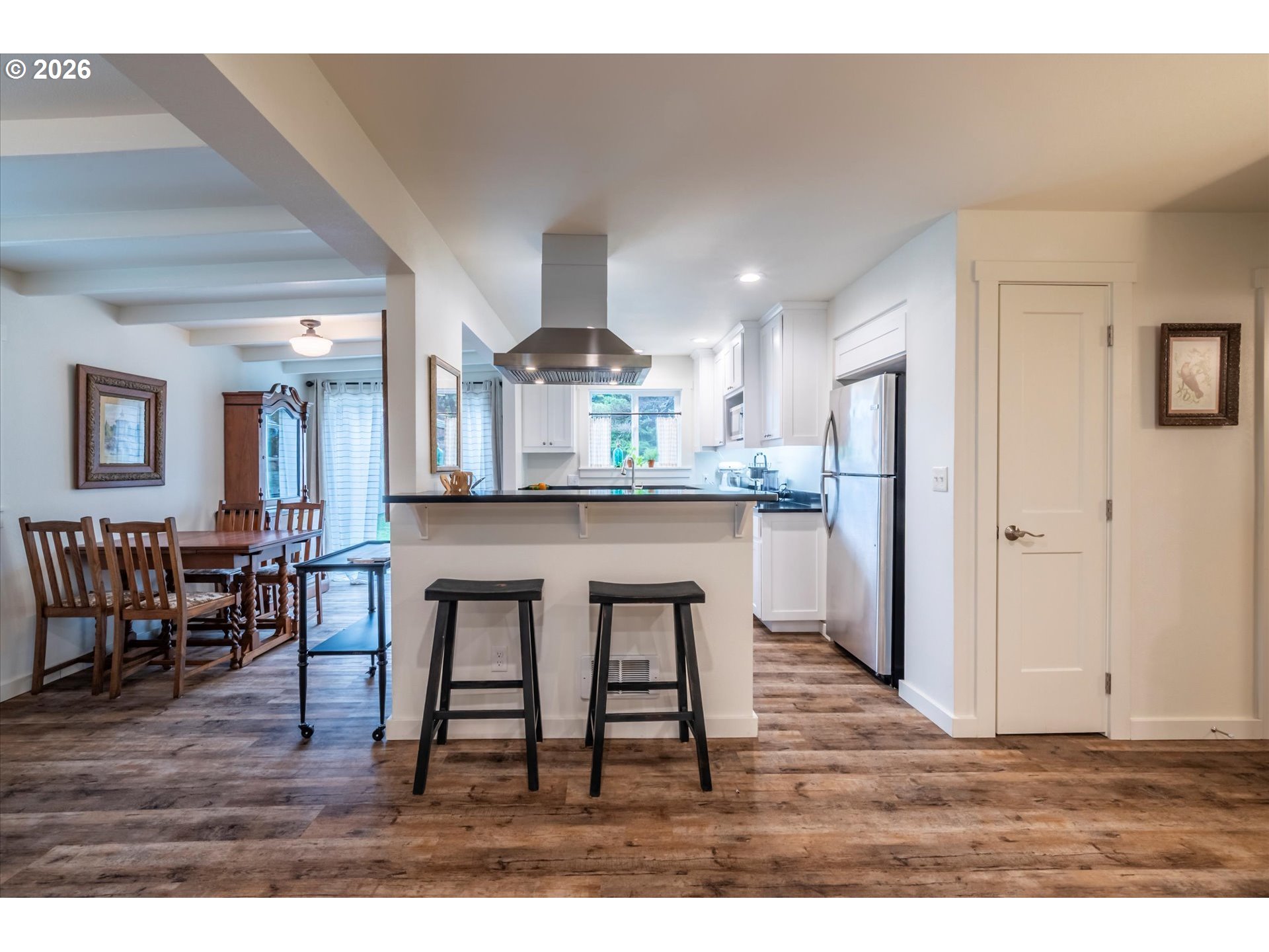 770 9th Street Southeast Bandon, OR 97411 - Photo 46 of 47 a kitchen with stainless steel appliances a dining table chairs and wooden floor