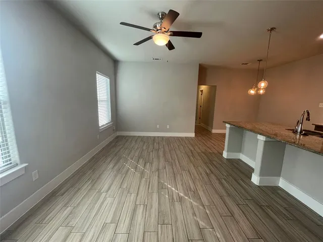 a view of an empty room with a window and wooden floor