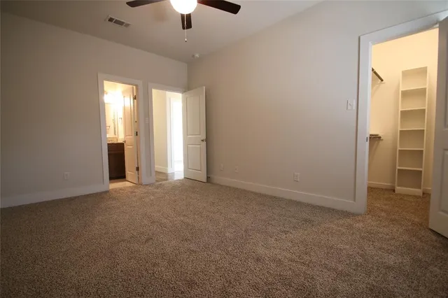 an empty room with chandelier fan