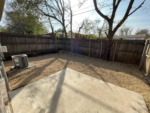 a view of backyard with wooden fence and trees