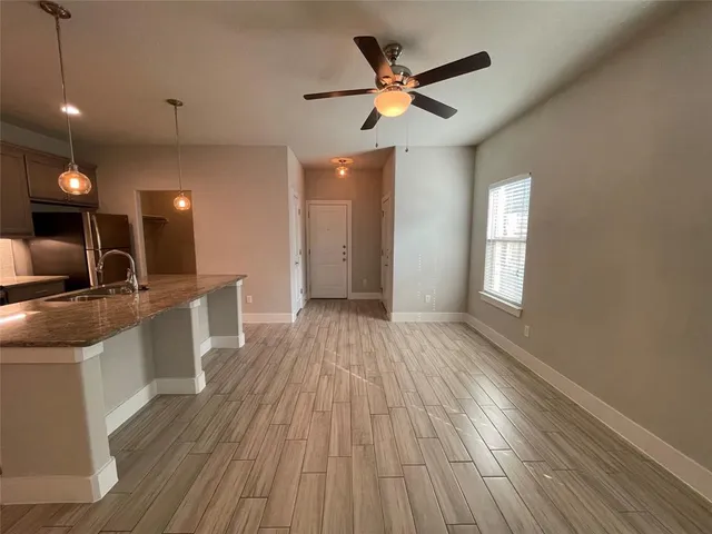 a view of a kitchen with a sink and wooden floor