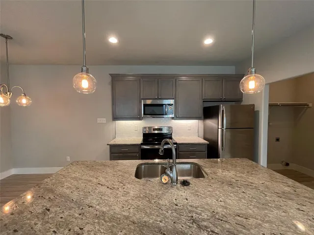 a kitchen with stainless steel appliances a refrigerator sink and microwave