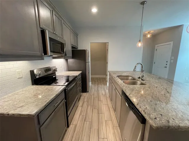 a kitchen with granite countertop stainless steel appliances and wooden cabinets