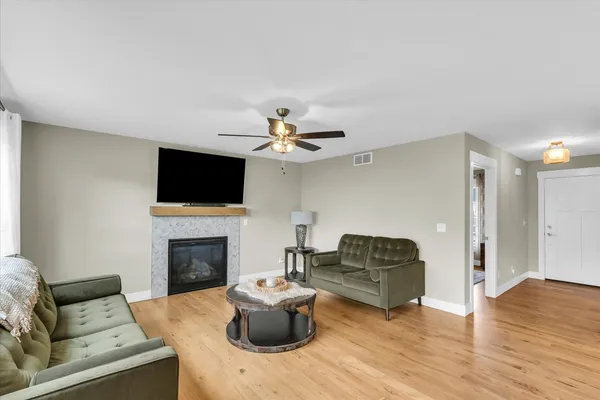 a living room with furniture a fireplace and a flat screen tv