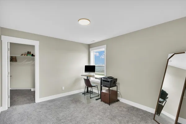 an empty room with wooden floor and mirror