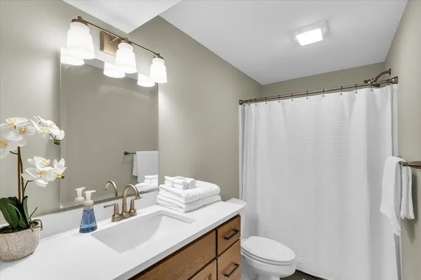 a bathroom with a sink a toilet and a mirror