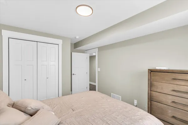 a bedroom with a bed and cabinet