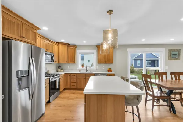 a kitchen with a refrigerator a stove top oven a sink dishwasher and cabinets with wooden floor