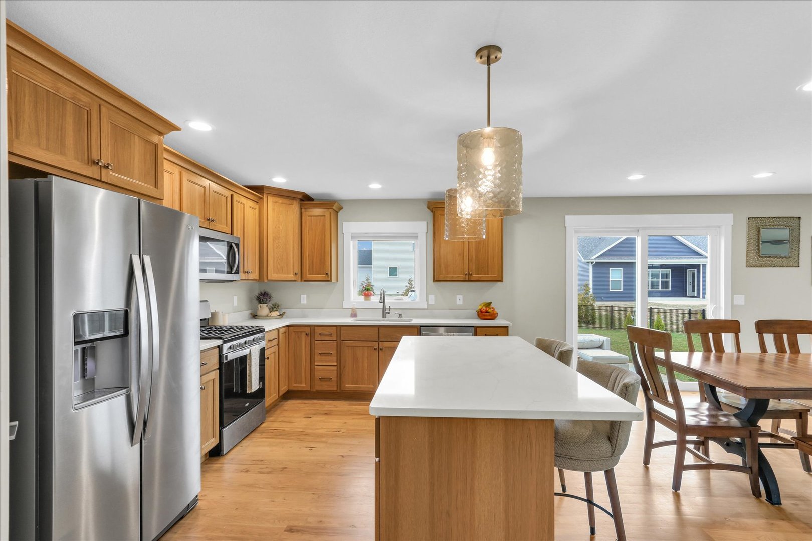 1403 Winterberry Road Savoy, IL 61874 - Photo 5 of 47 a kitchen with stainless steel appliances granite countertop a stove refrigerator a dining table and chairs with wooden floor