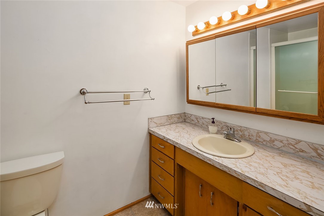 4216 Southwest Myrtle Street Seattle, WA 98136 - Photo 12 of 21 a bathroom with a granite countertop sink and a mirror
