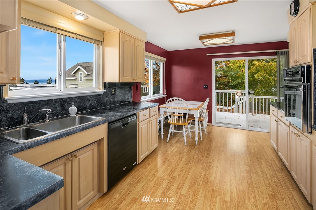 4216 Southwest Myrtle Street Seattle, WA 98136 - Photo 5 of 21 a kitchen with stainless steel appliances granite countertop wooden floors stove and sink