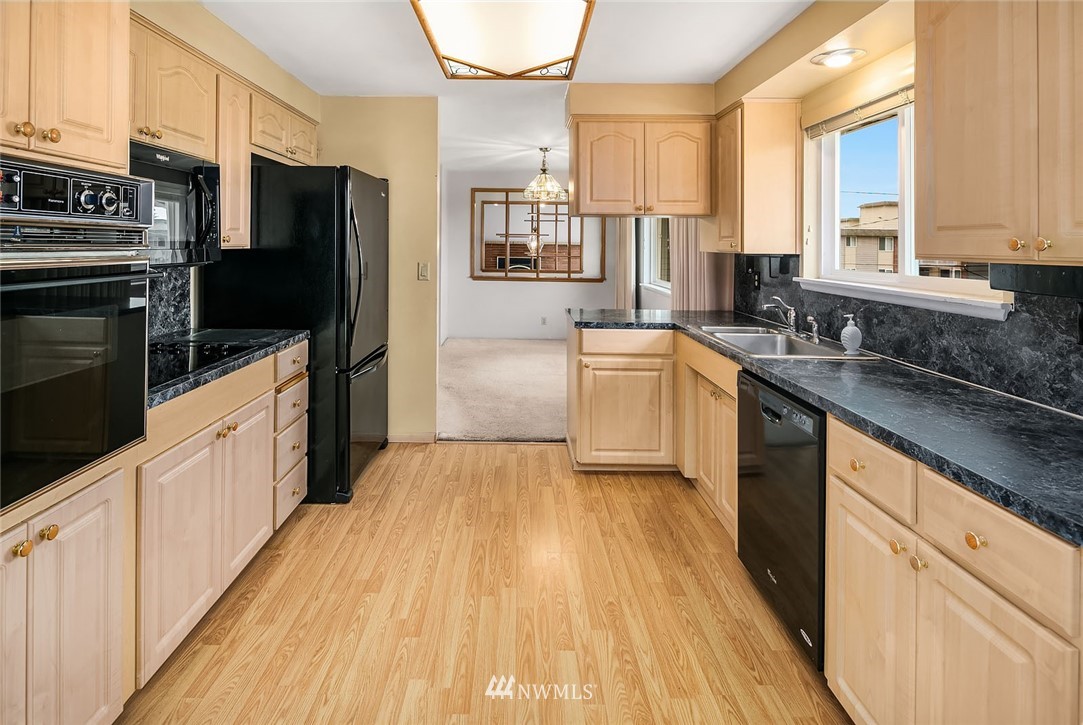 4216 Southwest Myrtle Street Seattle, WA 98136 - Photo 7 of 21 a kitchen with stainless steel appliances a sink cabinets and wooden floor