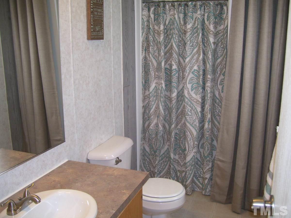 249 West O Painter Road Timberlake, NC 27583 - Photo 13 of 20 a white toilet sitting next to a shower curtain