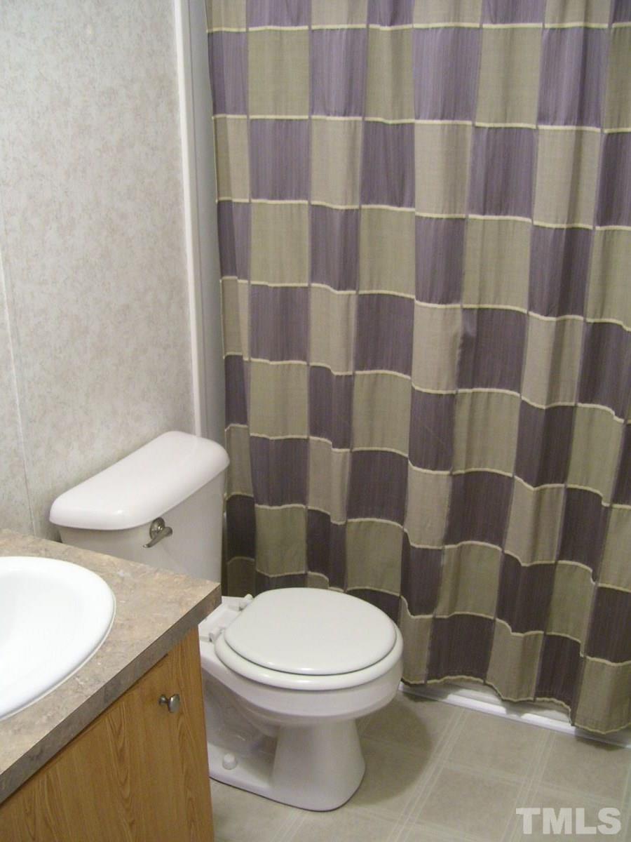 249 West O Painter Road Timberlake, NC 27583 - Photo 9 of 20 a white toilet sitting next to a shower curtain