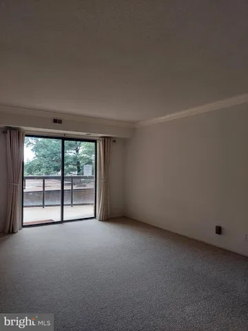 a view of a building with a small yard and large trees