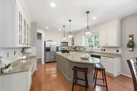 a large kitchen with granite countertop counter space a sink appliances and cabinets