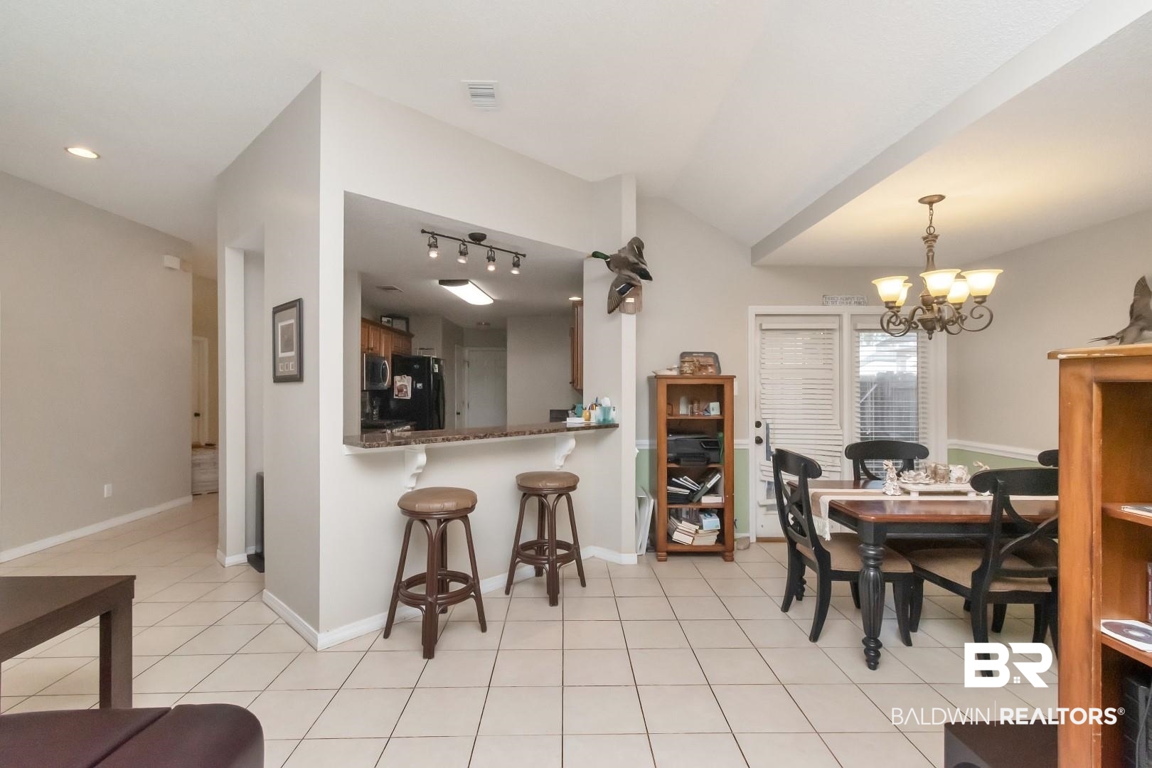 29221 Canterbury Road Daphne, AL 36526 - Photo 9 of 17 Dining room with light tile patterned floors, vaulted ceiling, and an inviting chandelier