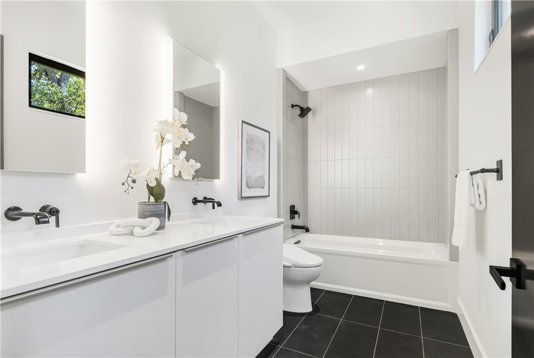 11851 Hopes Creek Road College Station, TX 77845 - Photo 35 of 50 a bathroom with a double vanity sink toilet mirror and bathtub