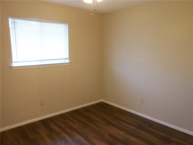 a view of a small space with wooden floor and a window