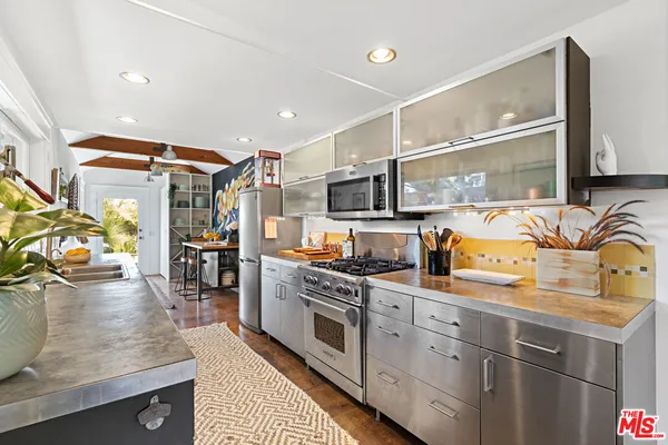 a kitchen with stainless steel appliances granite countertop a sink and stove top oven