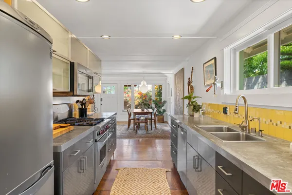 a kitchen with stainless steel appliances granite countertop a sink stove and cabinets
