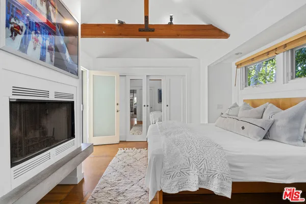 a bedroom with a large bed and a fireplace