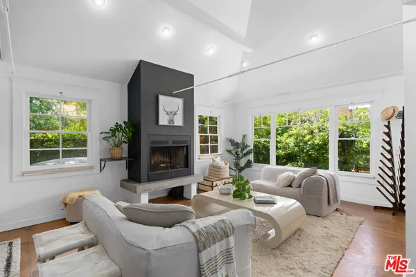 a living room with furniture a large window and a fireplace