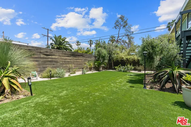 a view of a chair and table in backyard of the house