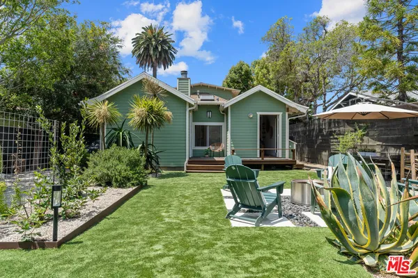 a view of a house with backyard sitting area and garden