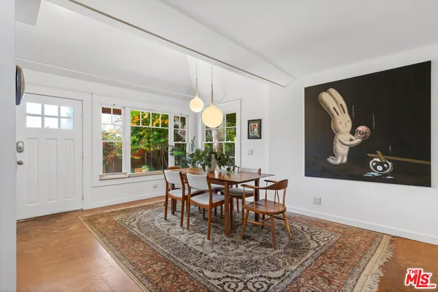 a dining room with furniture a rug and a large window