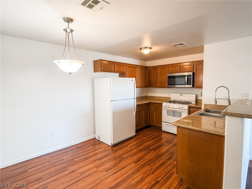 7701 West Robindale Road, Unit 110 Las Vegas, NV 89113 - Photo 4 of 21 A well-lit kitchen with rich wood flooring and warm cabinetry.