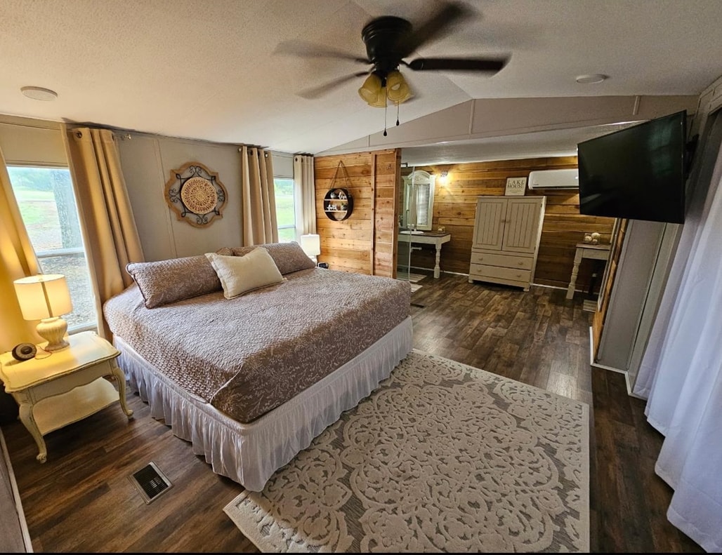 390 Wharf Road Savannah, TN 38372 - Photo 2 of 17 Spacious bedroom featuring wood-finish flooring, a ceiling fan, and shiplap accent walls