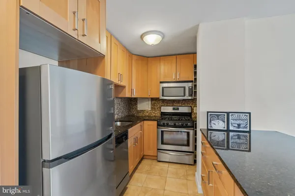 a kitchen with stainless steel appliances a refrigerator and a stove top oven