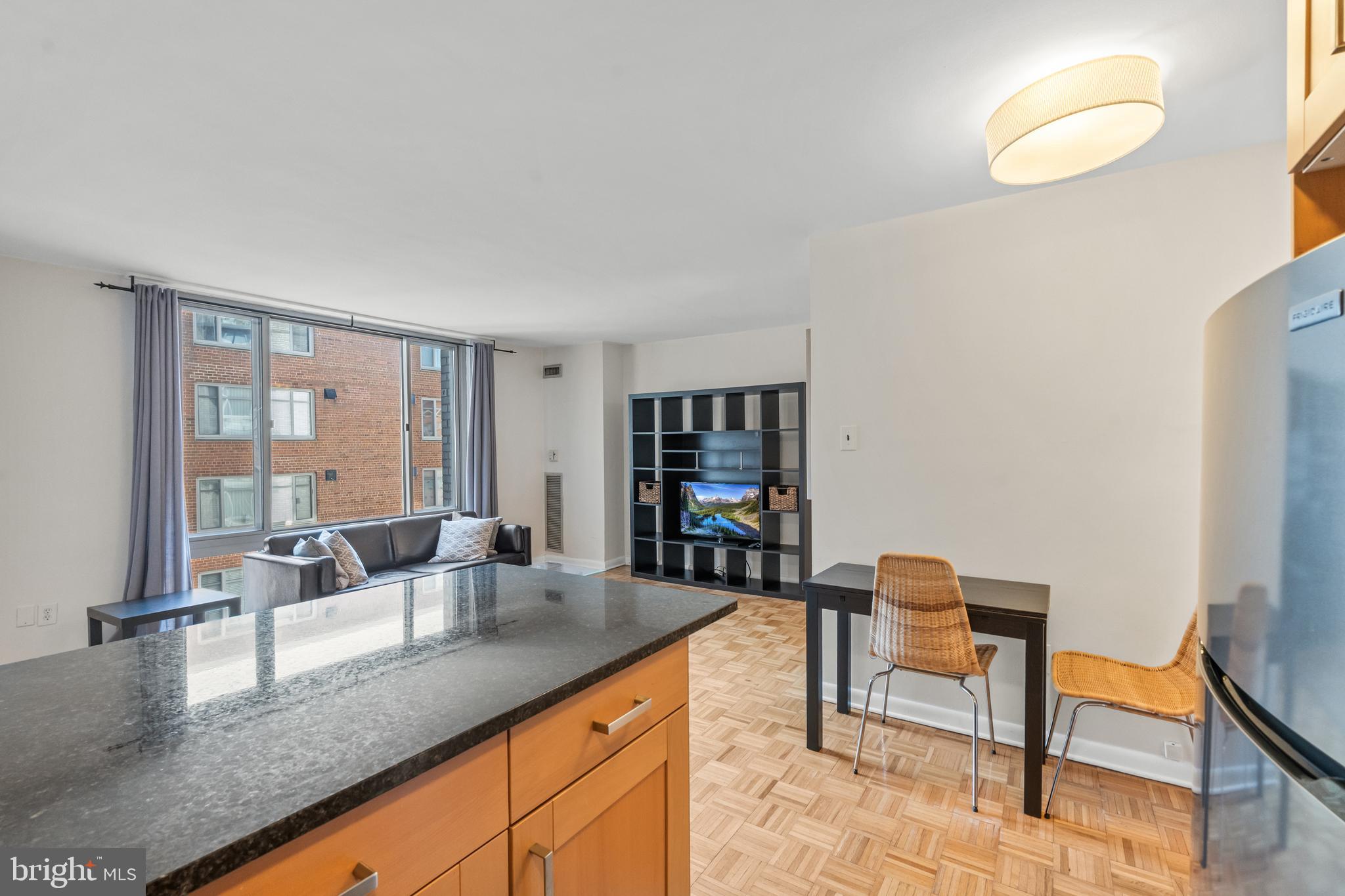950 25th Street Northwest, Unit 717 Washington, DC 20037 - Photo 5 of 19 a kitchen with granite countertop a table and chairs in it