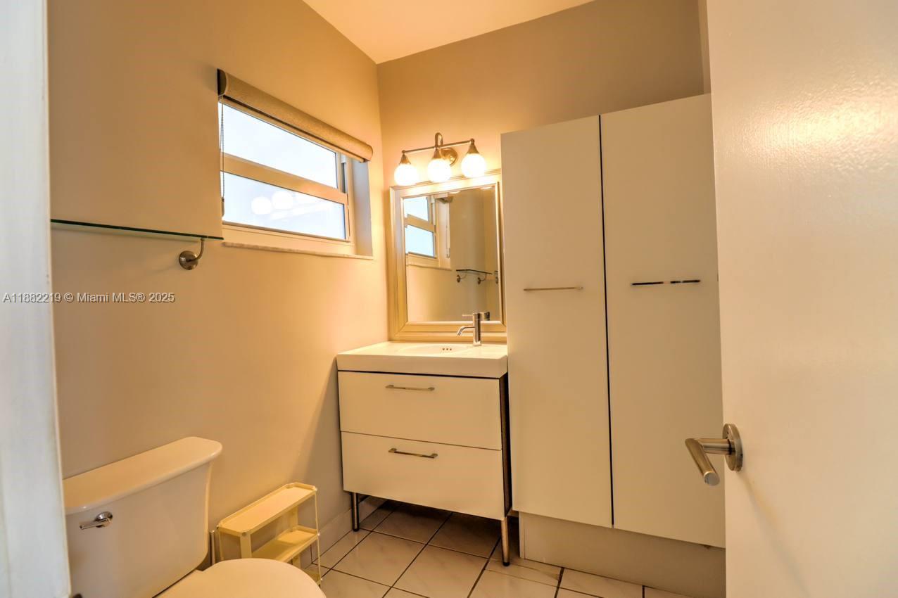 850 Northeast 12th Avenue, Unit 210 Hallandale Beach, FL 33009 - Photo 11 of 16 a bathroom with a granite countertop sink toilet and shower