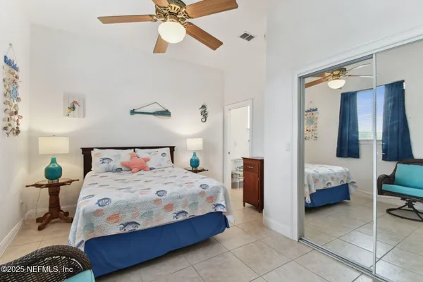 a bedroom with a bed and a chandelier fan