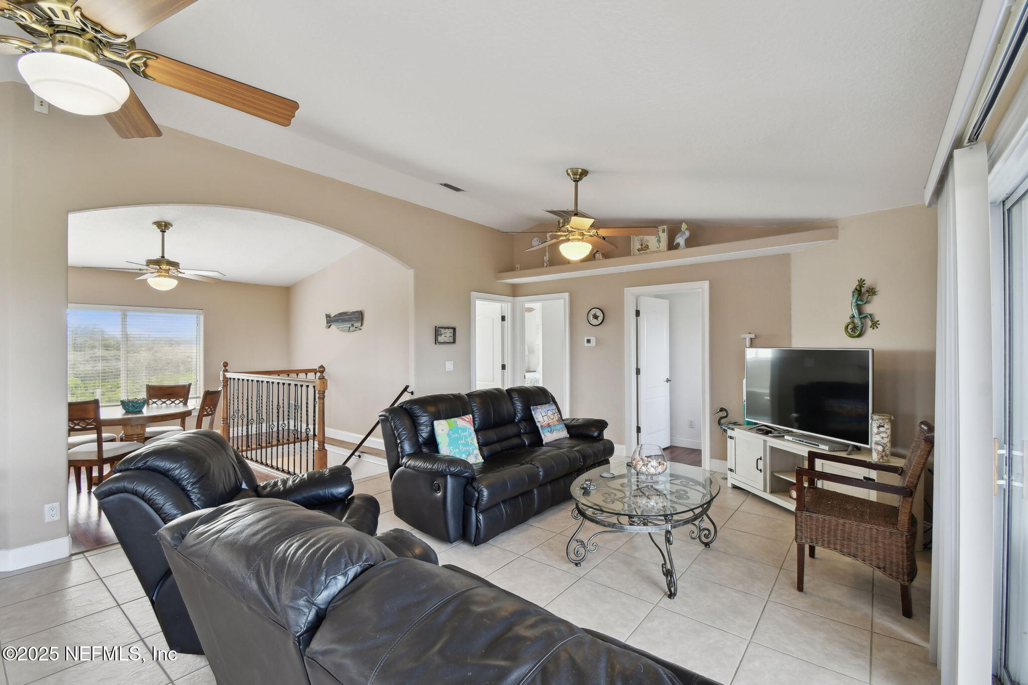 8961 A1A South St. Augustine, FL 32080 - Photo 25 of 62 a living room with furniture a flat screen tv and white walls