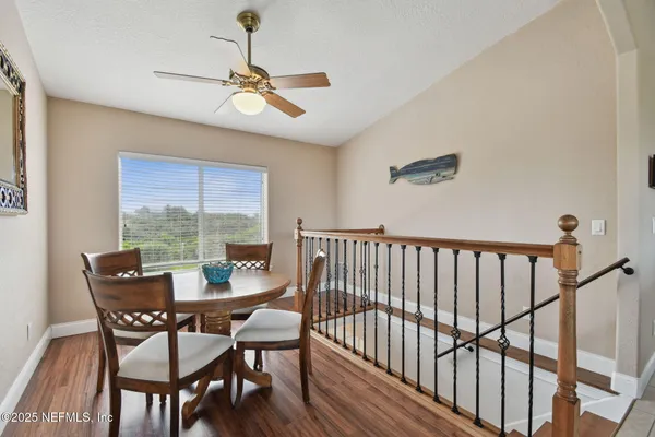 a kitchen with stainless steel appliances a stove a sink a dining table and chairs