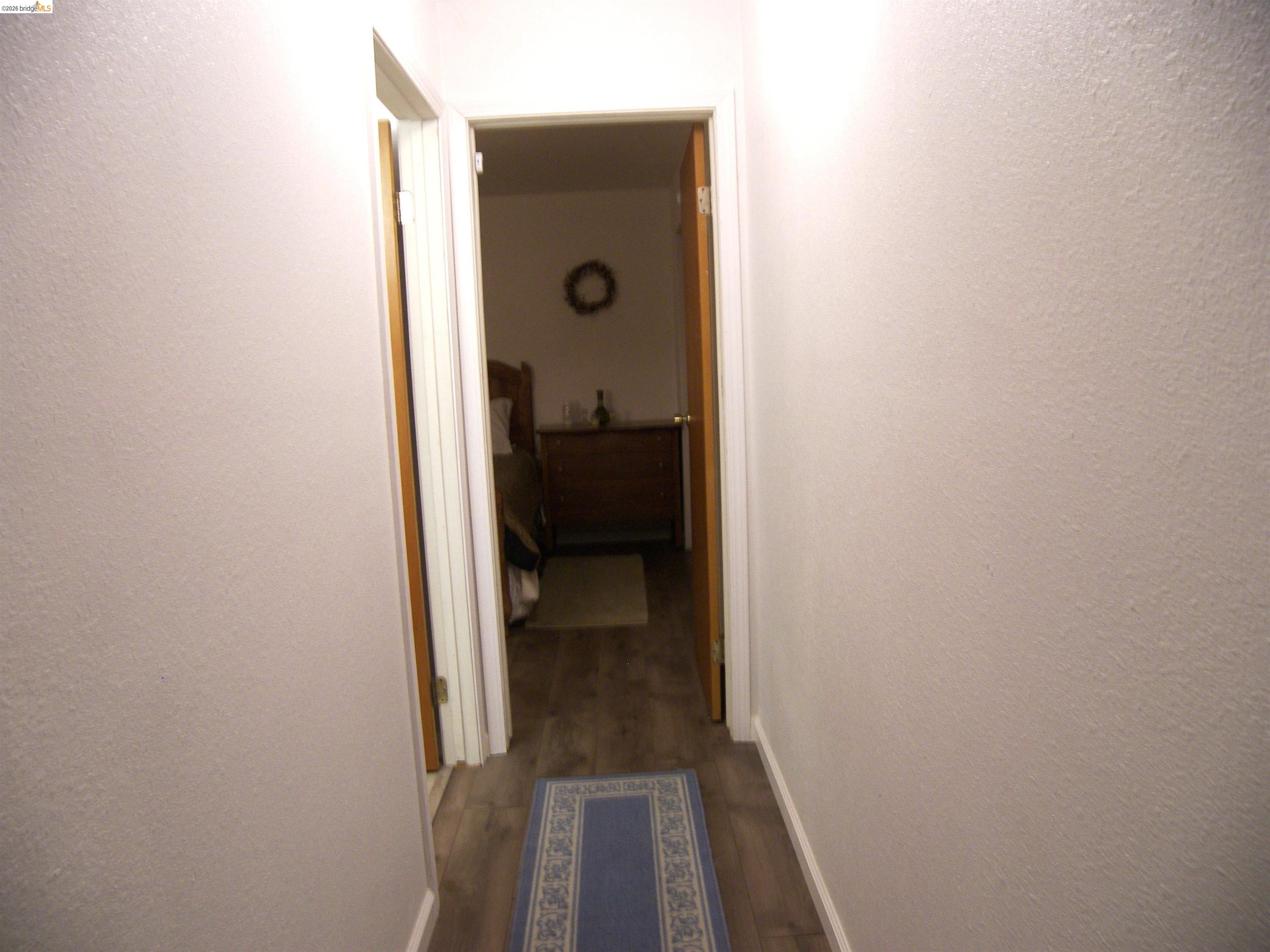 19215 Ferretti Road Groveland, CA 95321 - Photo 20 of 40 Hallway featuring wood-finish flooring and white baseboards