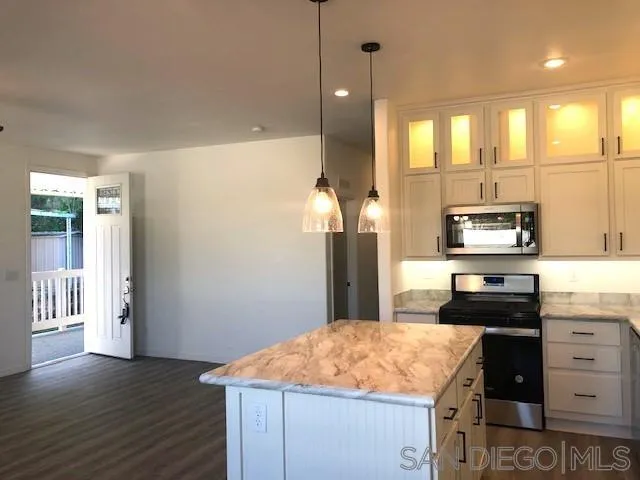 1315 Pepper Drive, Unit 18 El Cajon, CA 92021 - Photo 4 of 10 a kitchen with kitchen island a counter top space appliances and cabinets