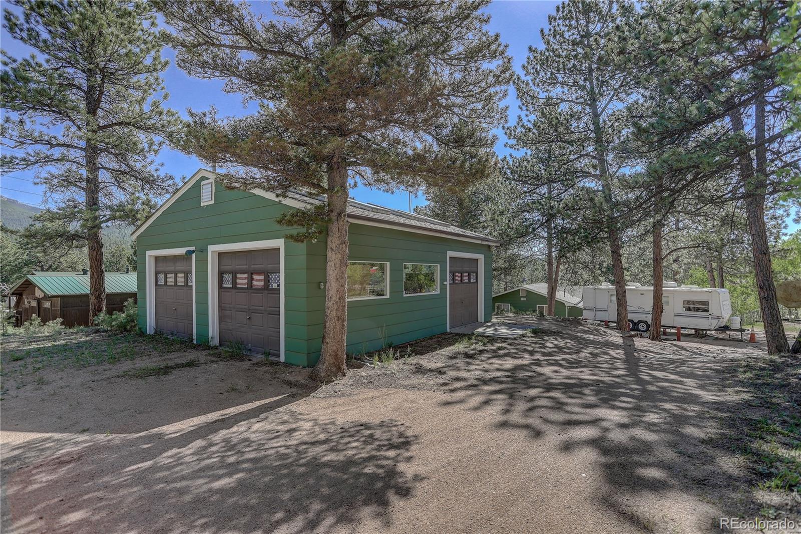 191 Anderson Road Bailey, CO 80421 - Photo 2 of 38 a view of a brick house next to a yard with large trees
