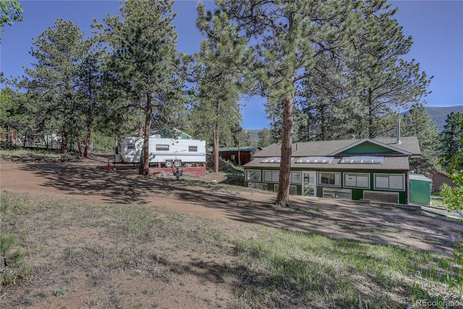 191 Anderson Road Bailey, CO 80421 - Photo 33 of 38 a house with trees in front of it