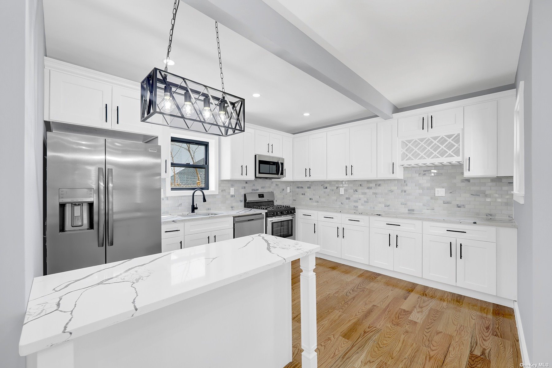 a kitchen with stainless steel appliances kitchen island granite countertop a refrigerator a sink dishwasher a oven with white cabinets and wooden floor