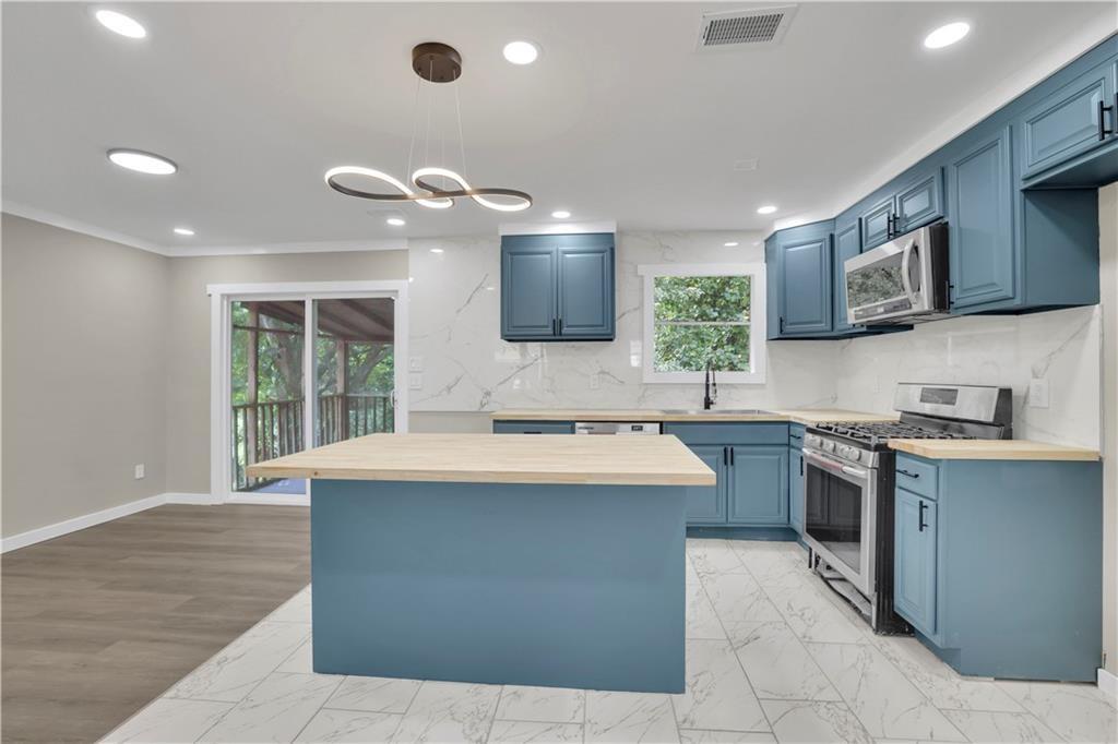 4913 Windsor Downs Drive Decatur, GA 30035 - Photo 12 of 26 a kitchen with kitchen island a sink stainless steel appliances and cabinets
